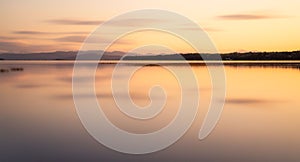 View of a beige sunset sky reflecting on the Lake Champlain