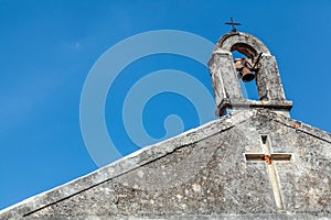 View of belfry with rusted bell and two crosses