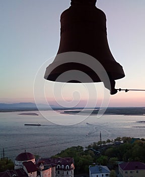 Bell on the background of the setting sunset