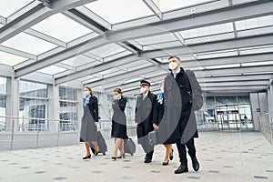 View from below. Airplane crew in uniform is going to the work together