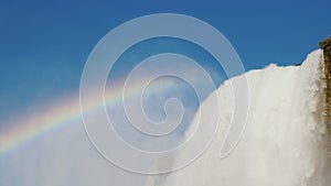 View from below at the beautiful Niagara Falls and the rainbow above it