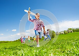 View from below of boy with toy and kids running