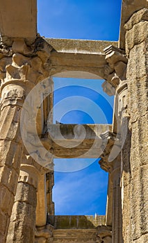 View from below of the granite row columns of the Roman Temple of Diana with a dove perched on its beams, under a clear blue