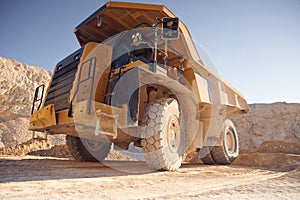 View from below of haul truck that is parked in the quarry at sunny daytime