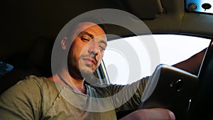 View from below a man in a car with a phone in his hand.
