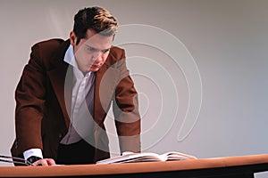 View from below of a man with his hands on his desk thinking about his work. Business man seriously thinking on a white background