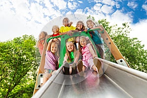 View from below of many kids on playground chute