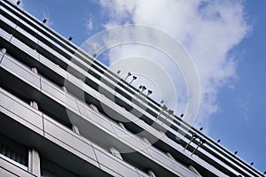 A view from below on an office building in a business district against a blue sky