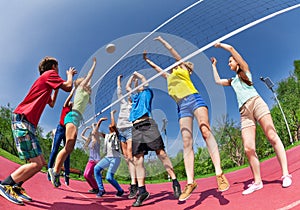 View from below of teens playing volleyball