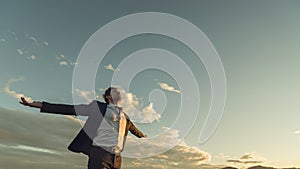 Young businessman relaxing under evening sky