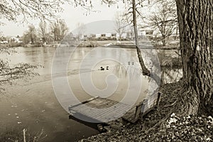 View on bench and footbridge in winter season in black and white sepia, ljubljana, slovenia