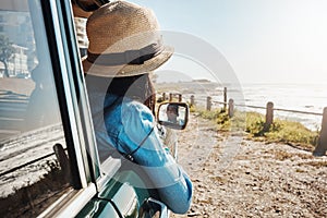 The view is the best part. a young woman enjoying a road trip along the coast.