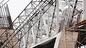 View of big grey metallic bridge over river with fast moving truck