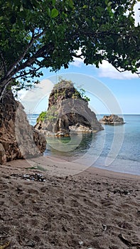 view of the big rock on the red granite sand beach