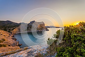 View of Black Sea bay with rocky shore lit with low sunrise light