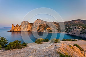 View of Black Sea bay with rocky shore lit with low sunrise light