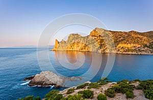 View of Black Sea bay with rocky shore lit with low sunrise light