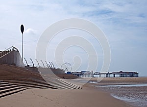 View of blackpool showing beach seafront and promenade with pier in the distance on a sunny summers day