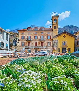 The view through the blooming flower bed on scenic facade of historical house on Piazza Indipendenza of Bellinzona, Switzerland