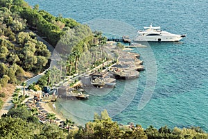 View on blue Aegean sea, white yacht in small pier near hotel