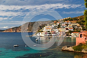 A view at blue bay, sea-front street of Asos village, greek colorful houses and turquoise Ionian Sea water. Luxury