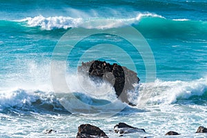 View of the blue Cantabrian sea with waves on rocks on the coast of Liencres, Cantabria,