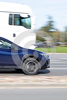 View of a blue car from the side, a fast driving car in traffic. Motion blur
