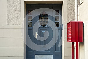 A view of a blue front door and a red mailbox in an apartment building