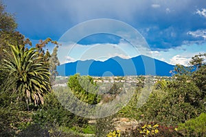 View on blue mountains covered in shadow and heavy rain clouds over Orange County, California