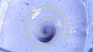 View of blue purple liquid spinning in a circular patterning.
