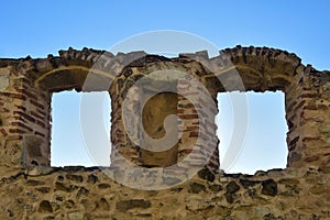 View of blue sky through arched windows of loophole in wall of an ancient fortress. Copy space. photo