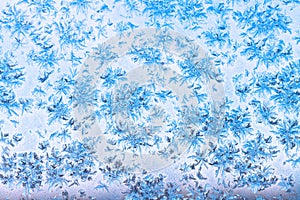 View of blue sky through snowflakes and frost