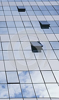 View of blue windows in a skyscraper modern offices building - concept of people at work at life - openand close windows with sky