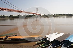 Un barco sobre el un rio suspensión puente 