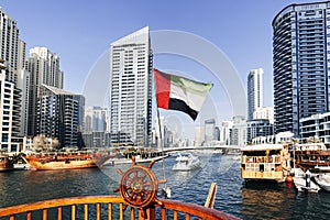view from a boat in sea to the flag of the United Arab Emirates and the cityscape with the tower. boat trip on a yacht.