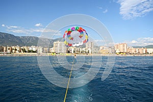 View from a boat to tied parachute with woman