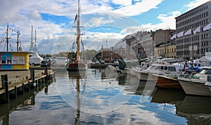 View of boats moored at harbor against cloudy sky