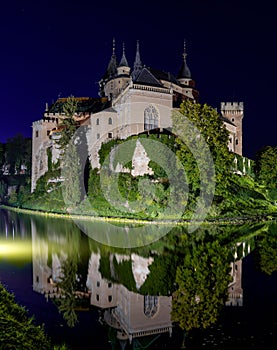 View of the Bojnice Castle with reflections in the water at night