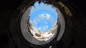 View from the bottom blue sky with white clouds surrounded by stone walls,hope for freedom and happiness, tower of a