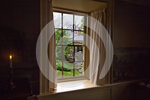 View  of the brick house  through the old window.