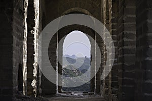 View through a brick window of a Fortress Guard Tower of Mutianyu, a section of the Great Wall of China during summer