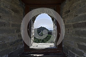 View through a brick window of a Fortress Guard Tower of Mutianyu, a section of the Great Wall of China during summer
