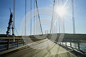 View on the bride and asphalt road through car`s windscreen with a stripe relief in sunny day