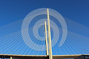 View of the bridge against the blue sky. The cables and high pylons of this long cable-stayed road bridge. Steel and