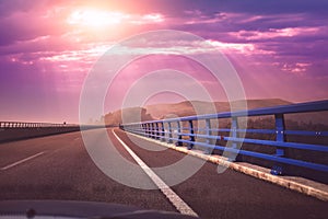 View of the bridge over the river through the windscreen during sunset