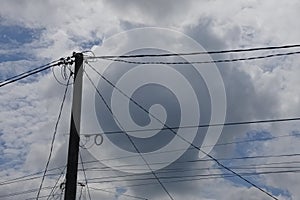 view of bright cloudy sky and electric poles and cables