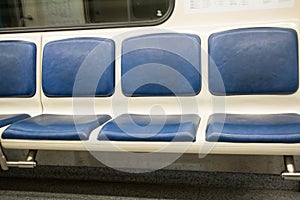 Contemporary inside space of the underground railway carriage with empty seats.