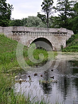 Old stone bridge, pond in summer park, Gatchina, Russia