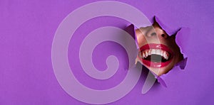 View of bright lips through hole in violet paper background. Make up artist, beauty concept. Cosmetics sale. Beauty salon