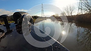 View of a British canal in rural setting from bow of narrowboat